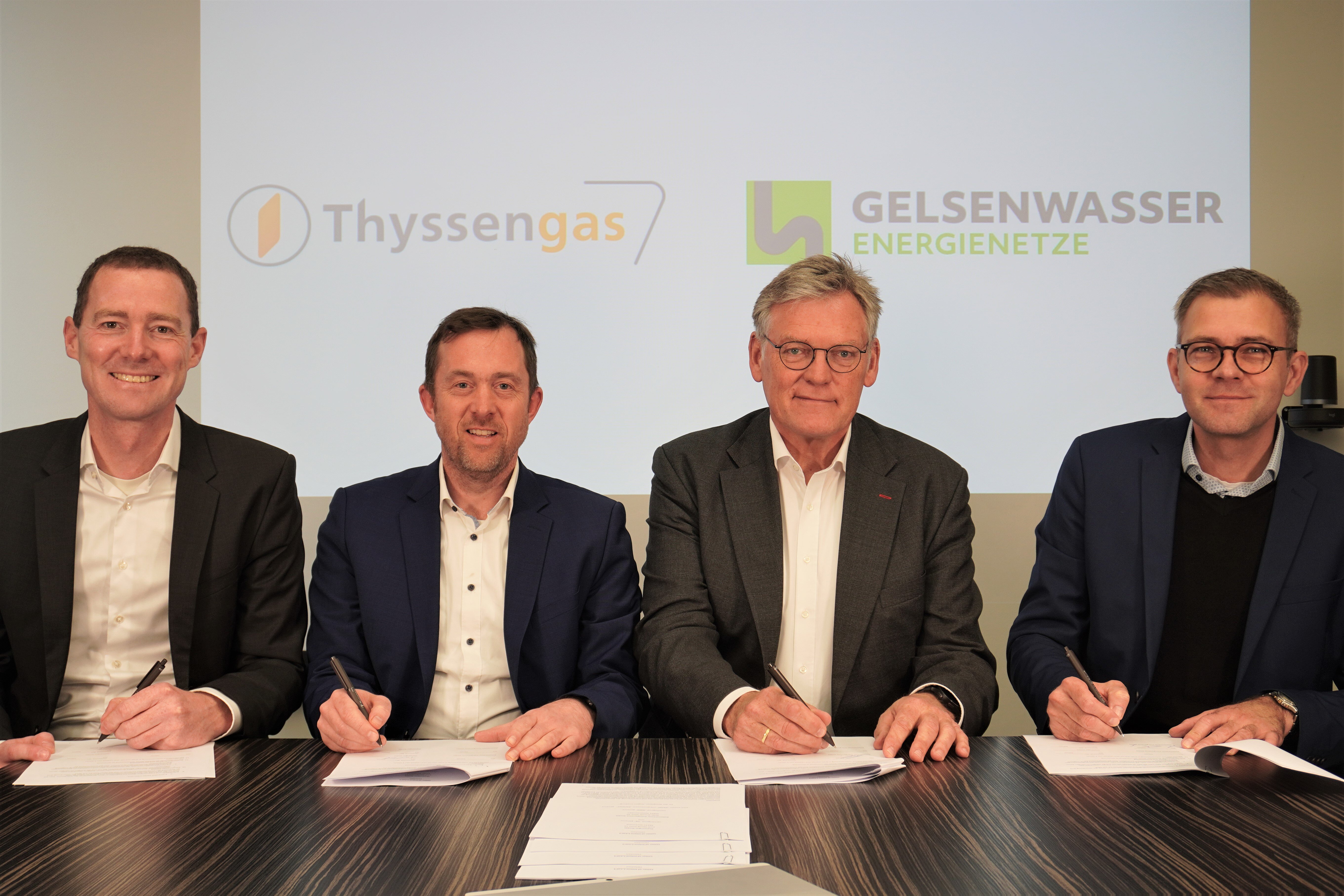 Vertreter von Thyssengas und Gelsenwasser Energienetze bei der Vertragsunterzeichnung vor einer Logowand.