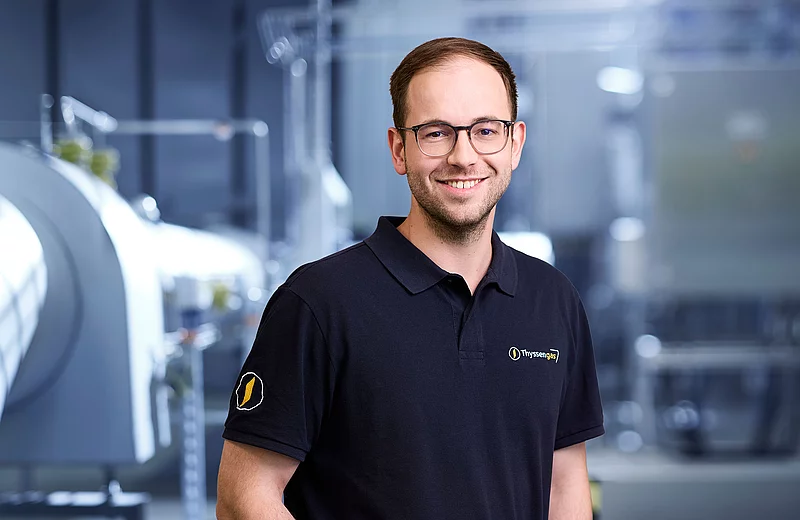 Portrait von Thyssengas-Mitarbeiter Michael Gertz in einem Polo-Shirt vor dem unscharfen Hintergrund einer Anlage.