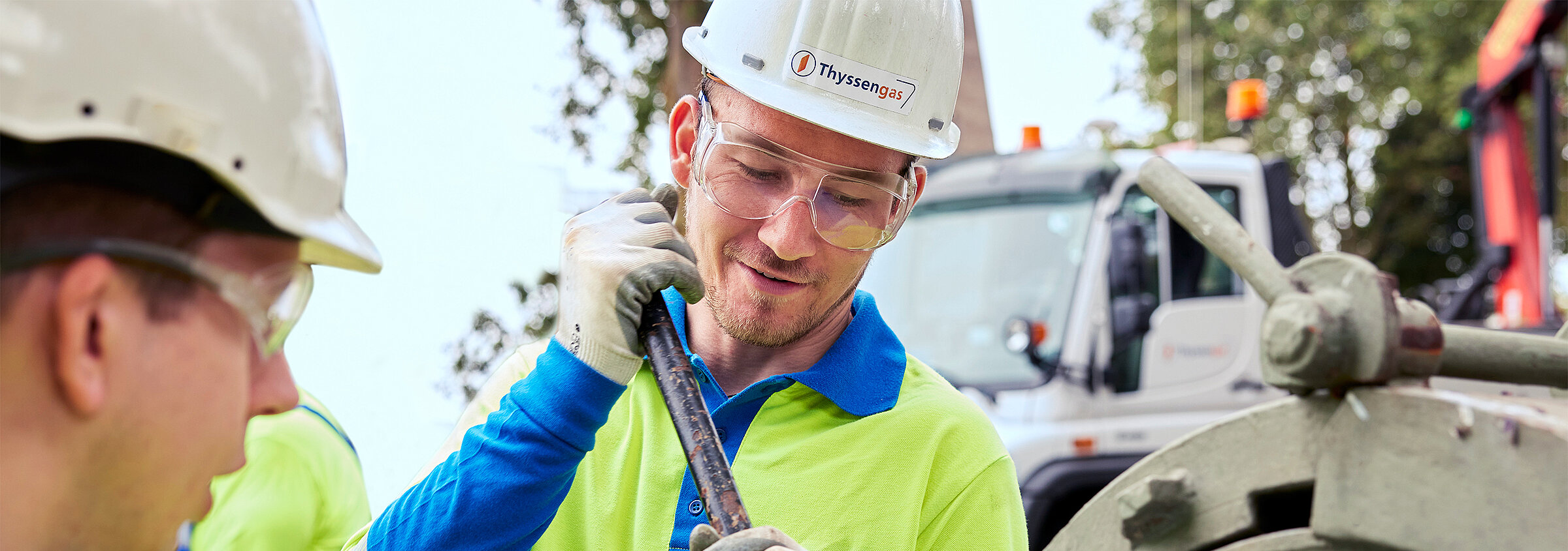 Zwei Thyssengas-Monteure in Schutzkleidung bei präzisen Wartungsarbeiten an einem Rohr des Fernleitungsnetzes.