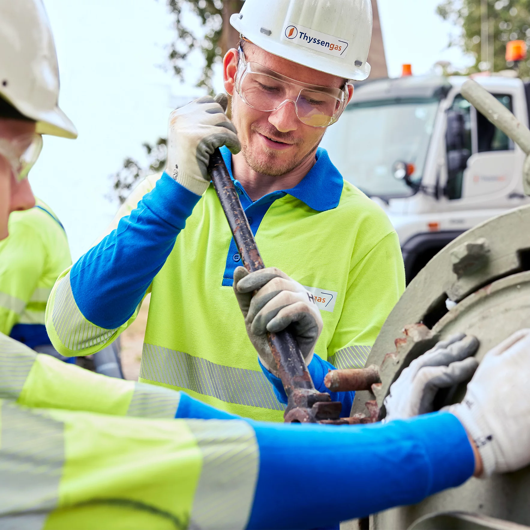 Zwei Thyssengas-Monteure in Schutzkleidung bei präzisen Wartungsarbeiten an einem Rohr des Fernleitungsnetzes.