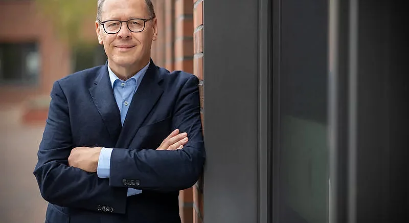 Portrait von Dr. Thomas Gößmann, Geschäftsführer von Thyssengas, mit verschränkten Armen vor einer Backsteinwand.