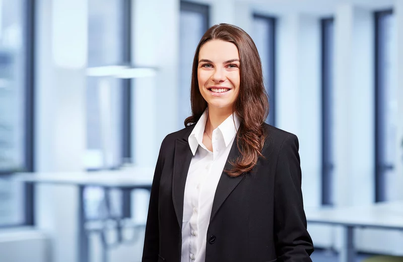 Portrait von Thyssengas-Mitarbeiterin Annika Preuß vor modernem Bürohintergrund.