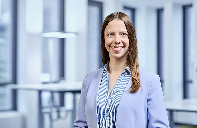 Porträt von Lena Behling vor modernem Büro-Hintergrund