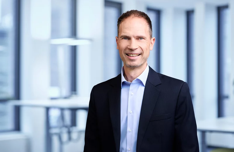Portrait von Thyssengas-Mitarbeiter Markus Pfefferkuch vor modernem Bürohintergrund.