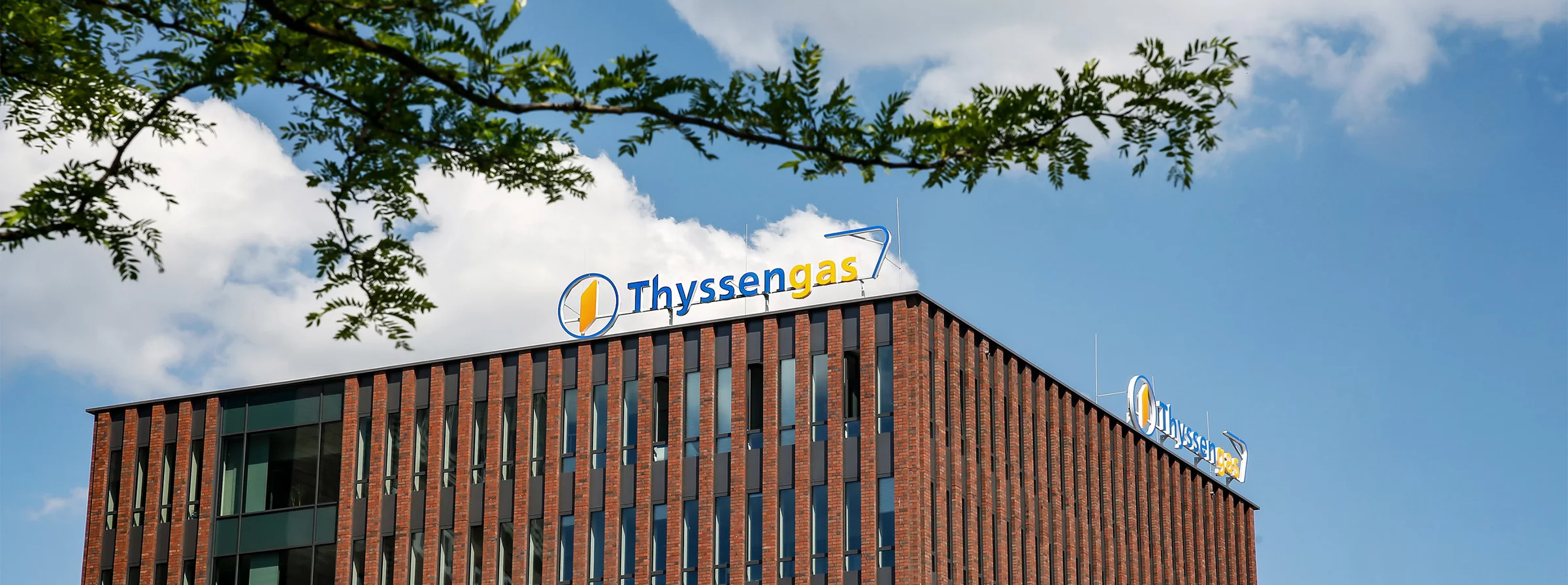 Modernes Backsteingebäude der Thyssengas-Zentrale in Dortmund bei sonnigem Wetter mit blauem Himmel.