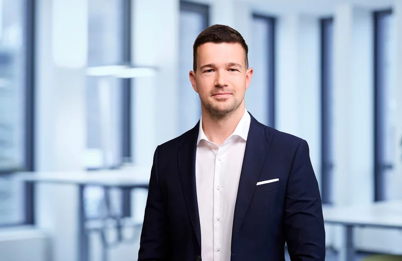 Portrait von Thyssengas-Mitarbeiter Lars Martin vor modernem Bürohintergrund.