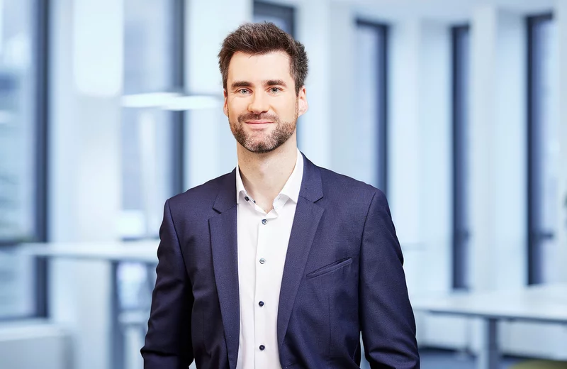Portrait von Thyssengas-Mitarbeiter Dr. Marc Fiebrandt vor modernem Bürohintergrund.