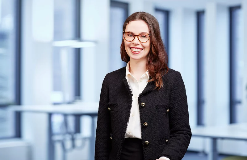 Portrait von Thyssengas-Mitarbeiterin Michelle Butzen vor modernem Bürohintergrund.