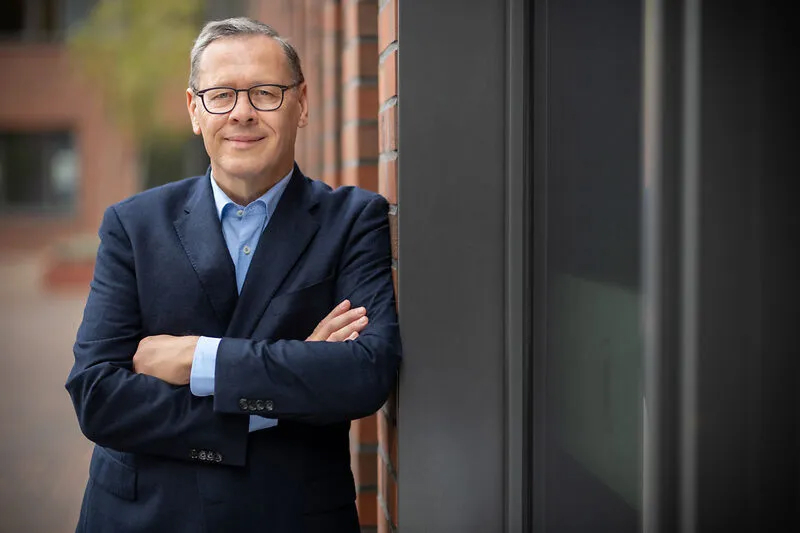 Portrait von Dr. Thomas Gößmann, Geschäftsführer von Thyssengas, mit verschränkten Armen vor einer Backsteinwand.