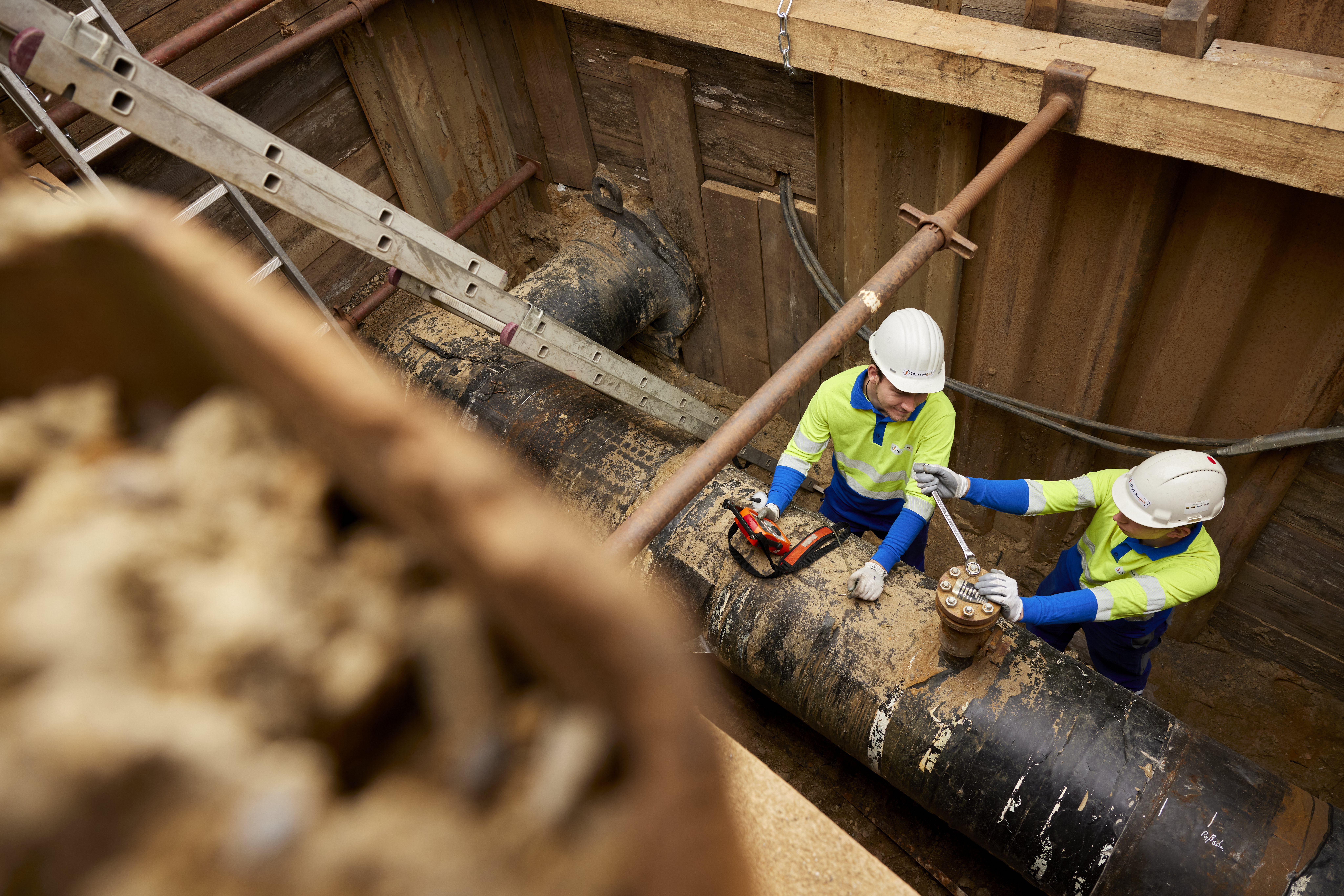 Zwei Thyssengas-Monteure bei Leitungsbauarbeiten an einer Pipeline in einer gesicherten Baugrube.